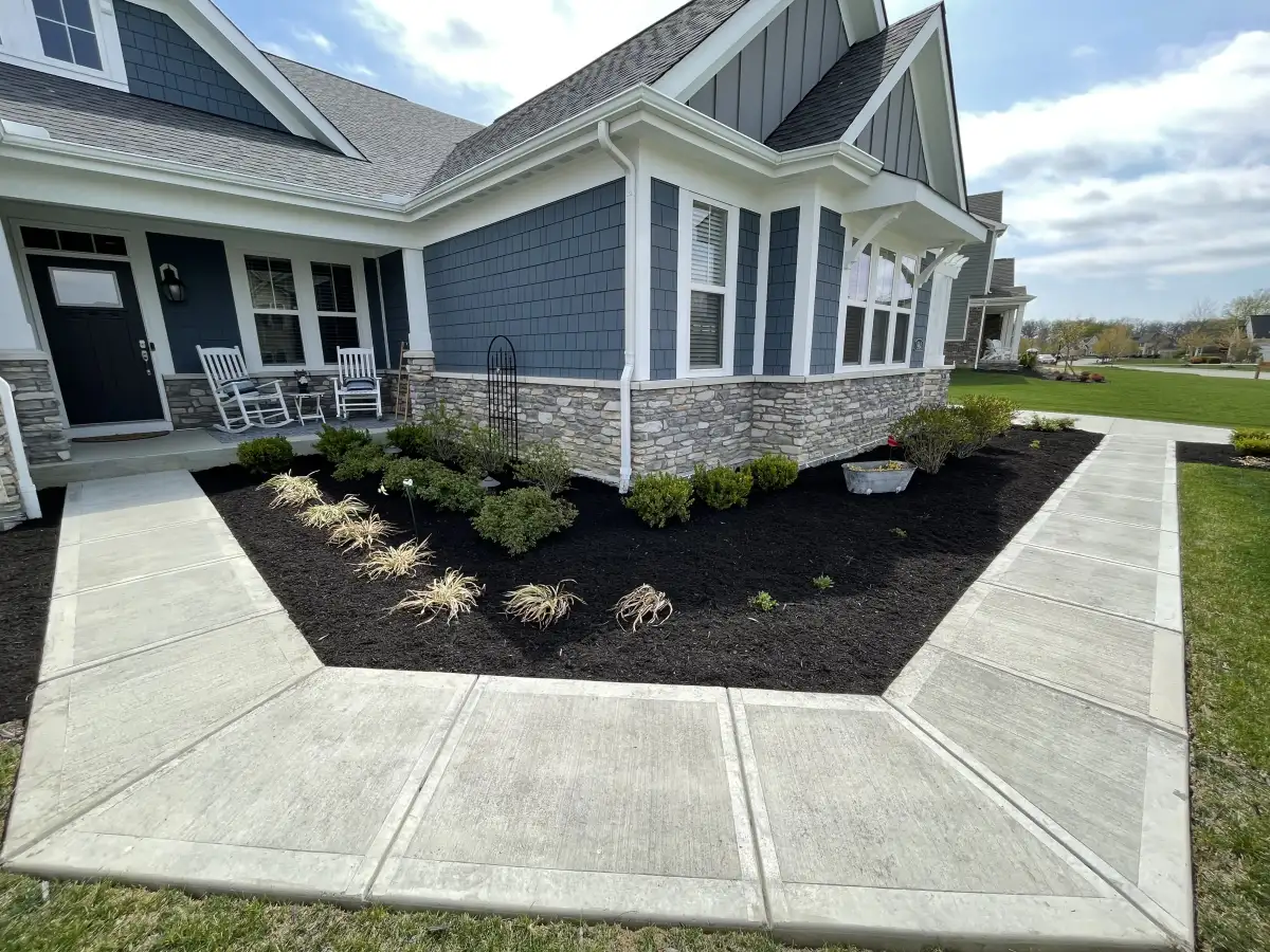 Fresh mulch installation in landscape beds with clean edging at a residential property in Marysville, Ohio